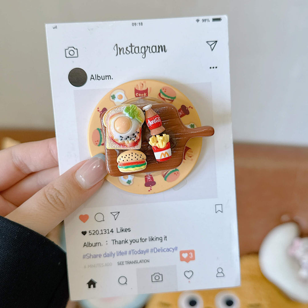 Close-up of the 3D miniature fast food cutting board pop grip on an Instagram-styled display card.