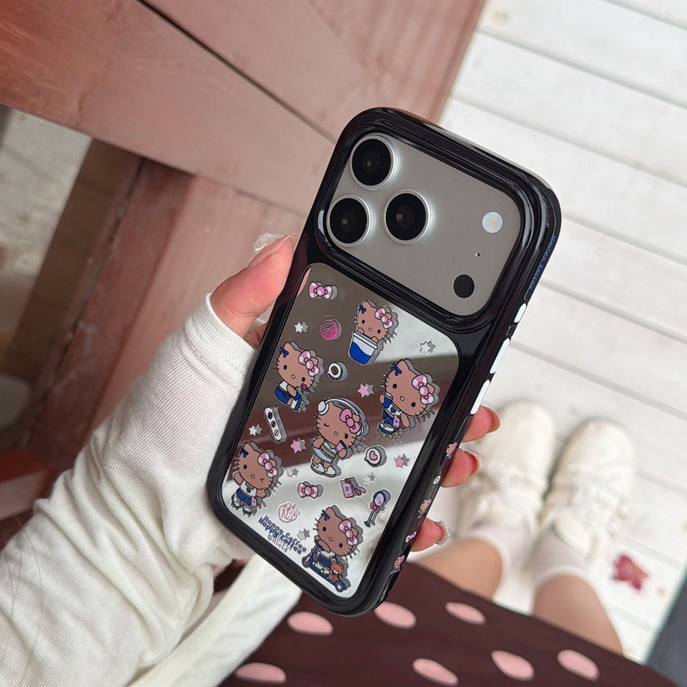 A person holding a silver metallic Hello Kitty mirror phone case against a casual background with white sneakers.