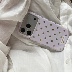 An aesthetic pastel purple polka dot phone case tucked inside a white linen shirt.