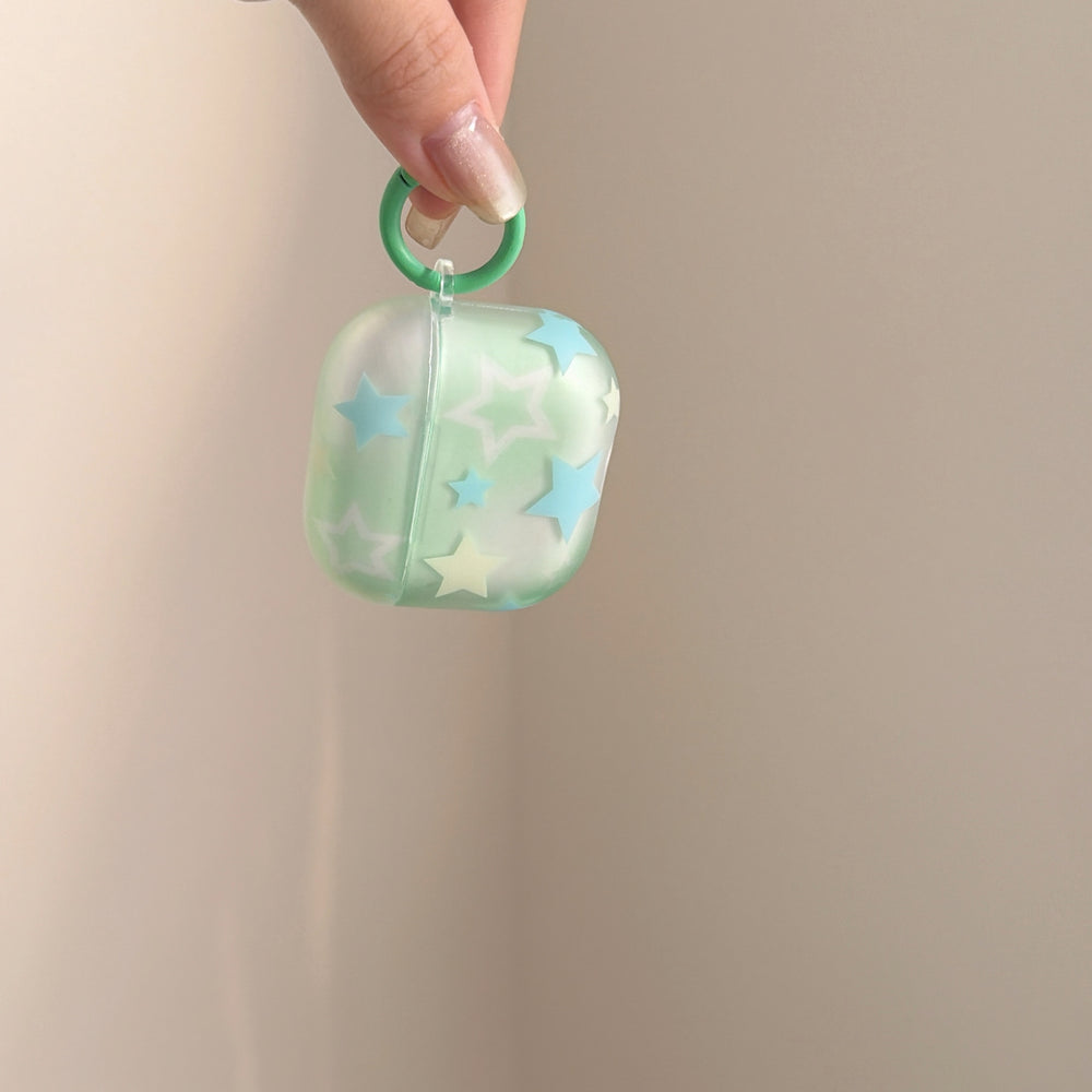 A hand lifting a translucent mint green starry AirPods case by its attached green ring carabiner.