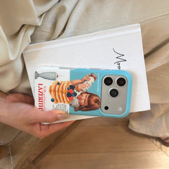 A hand holding a blue camera bumper pancake case horizontally flat against a white book.