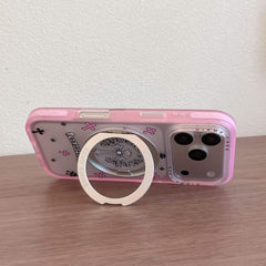 A Chrome Hearts style phone case propped horizontally on a table using its metal ring stand.