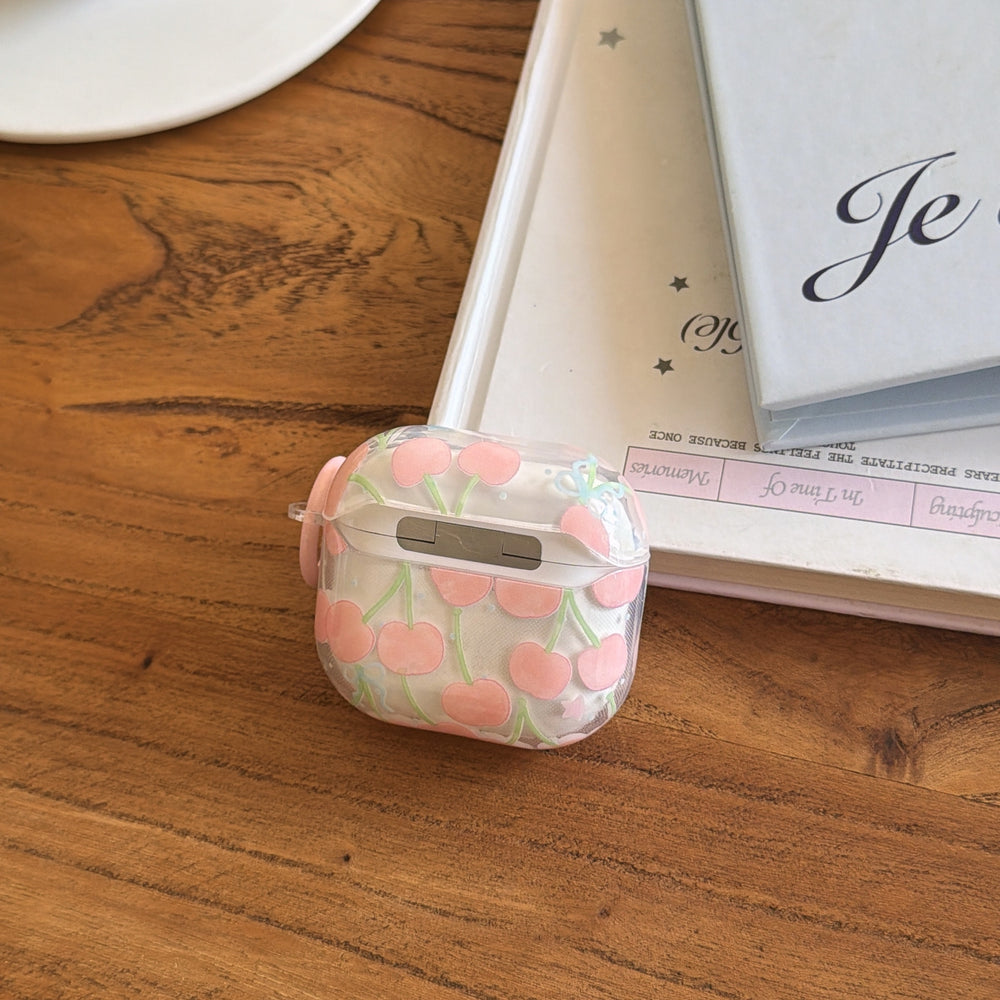 The back hinge view of a clear cherry AirPods protective case lying on a polished wooden table.