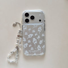 Product shot of a clear iris flower sketch phone case with an attached crystal and pearl charm strap on a white background.