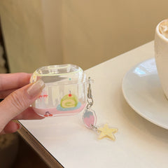 A clear kawaii cake AirPods case held next to a white coffee cup on a white tabletop.