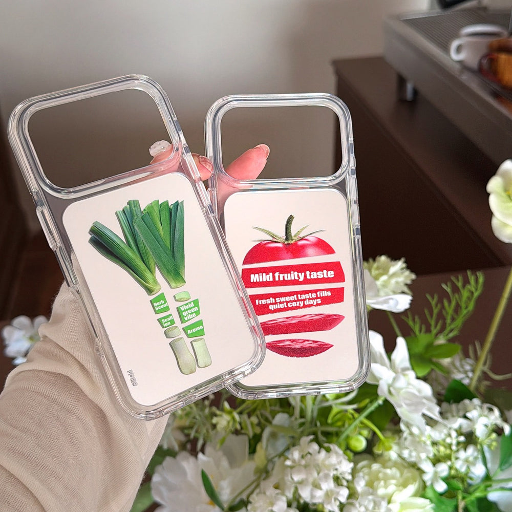 Hand showing the clear shockproof bumper design of tomato and leek print mirror phone cases against white flowers.