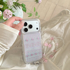 A silver phone case with a pink rose gate pattern held against a cream-colored dress.