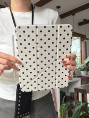 A mid-section view of a person holding an ivory cute aesthetic ipad protective shell vertically while resting a white stylus pen on the left side.
