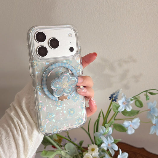 A hand holding a clear holographic flower phone case featuring a built-in cute blue floral phone socket.