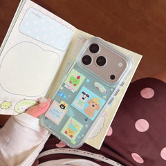 A transparent green phone case with cartoon animal patches placed on an open kawaii aesthetic notebook.