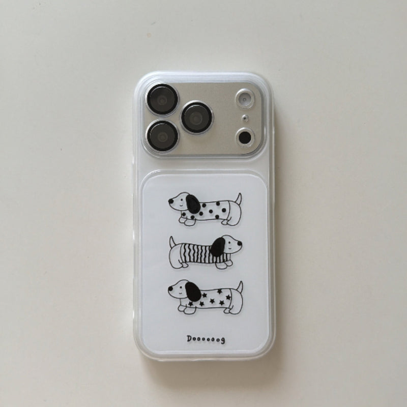 A flat lay view of a clear aesthetic iPhone case featuring three cute cartoon dachshund dogs on a white background.
