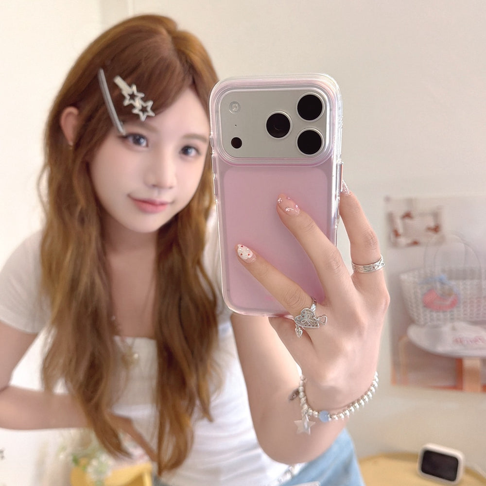 A girl taking a mirror selfie showcasing a cute pastel pink iPhone case with a protective camera frame.