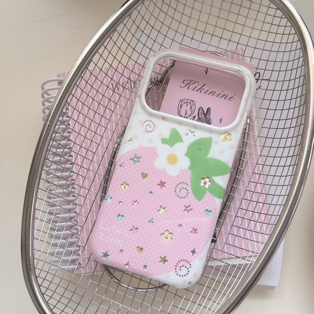A cute pink strawberry phone case placed inside a silver metal wire basket over a pink spiral notebook.