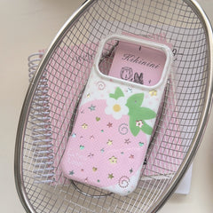 A cute pink strawberry phone case placed inside a silver metal wire basket over a pink spiral notebook.