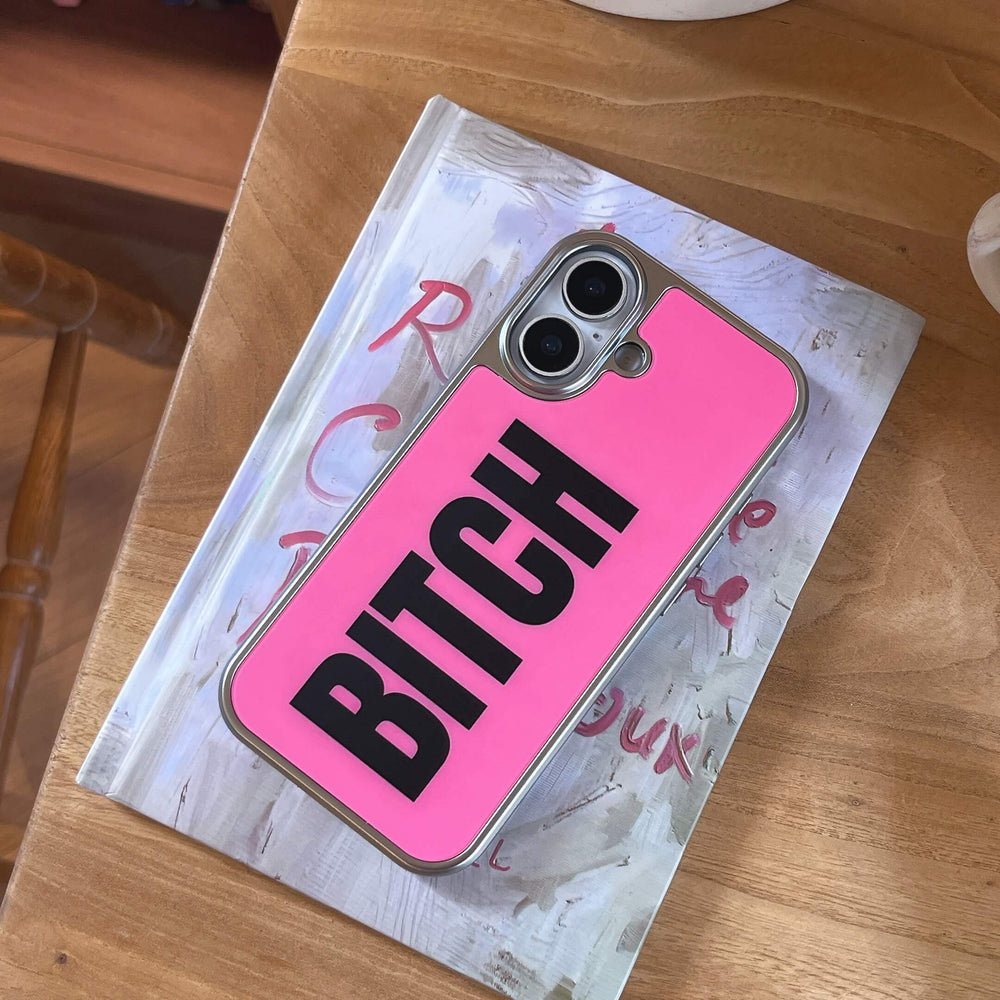 A hot pink phone case with a metallic silver border resting vertically on an aesthetic book.