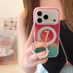 Woman taking a mirror selfie holding a clear iPhone case with a red and green gradient design, featuring a number 7 and an open silver magnetic ring kickstand.