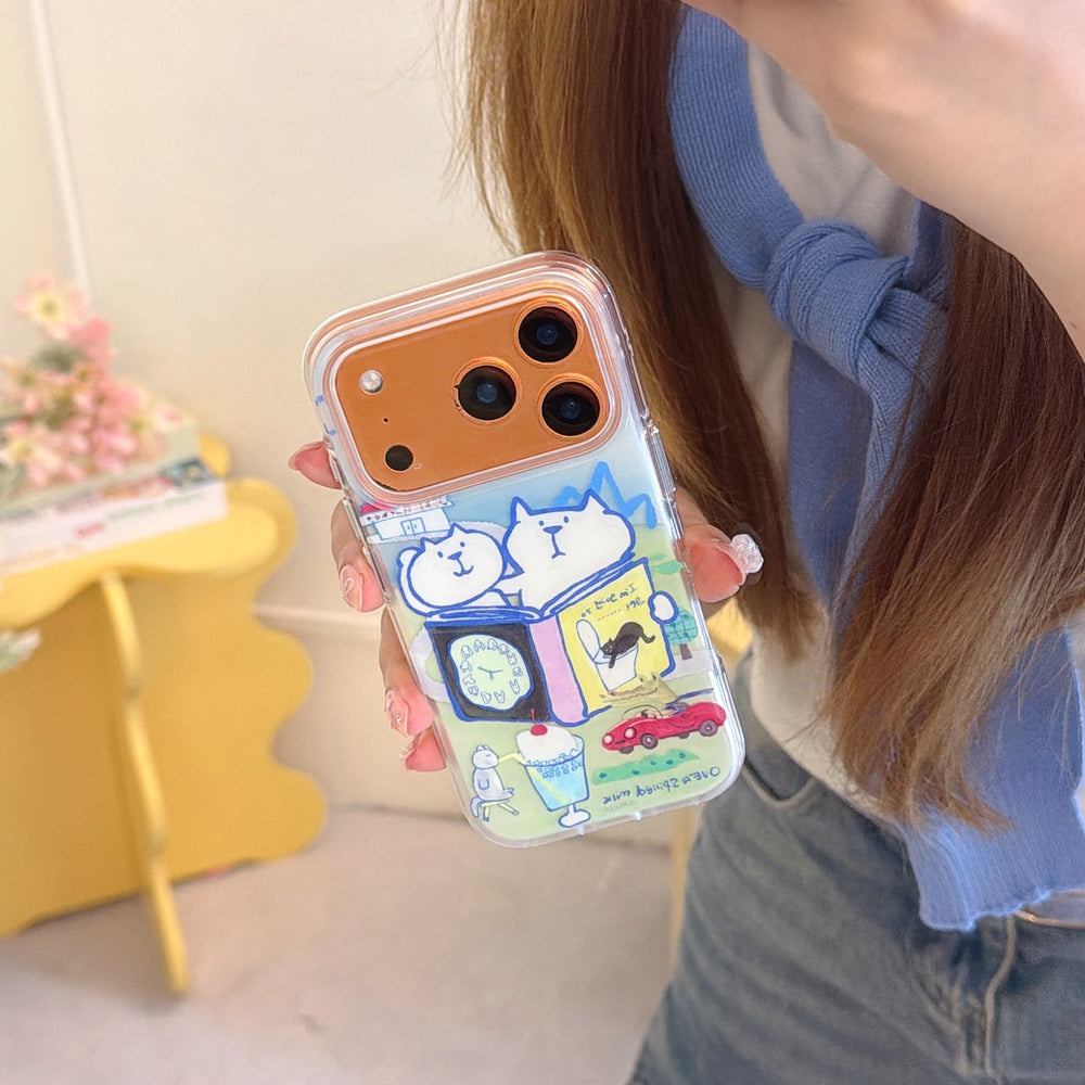 A hand showing a clear graphic phone case with a colorful Japanese doodle art print on a bronze-colored iPhone.