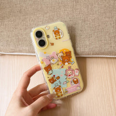 A clear yellow cartoon bear protective phone case resting on a hand with a textured beige fabric backdrop.