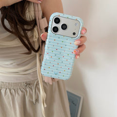A close-up view of a woman holding a kawaii blue stripe phone case vertically against her outfit.