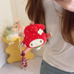 A woman holding a cute 3D silicone My Melody strawberry AirPods case with a red beaded keychain charm.