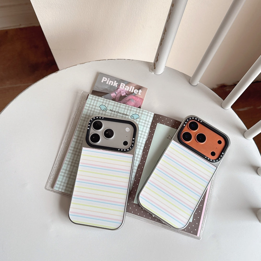 Two kawaii striped mirror phone cases in silver and orange gold colors displayed on a white chair.