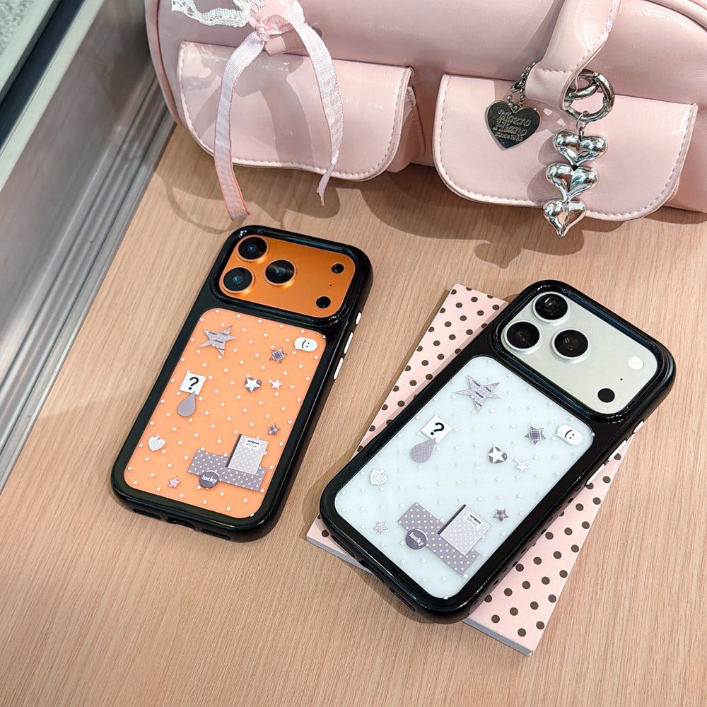 Flatlay view of orange and silver star mirror phone cases displayed together next to a pink handbag.