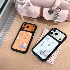 Flatlay view of orange and silver star mirror phone cases displayed together next to a pink handbag.