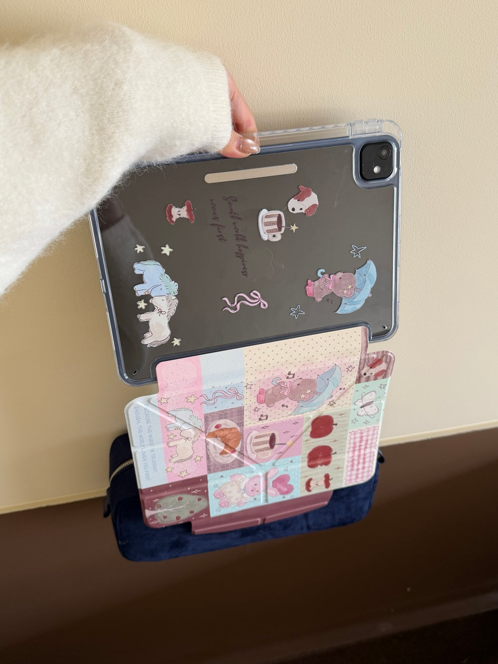 Demonstrating the strong magnetic split feature of a kawaii iPad case with the printed clear back shell hanging securely above the front cover.