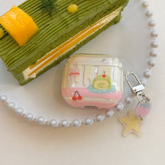 A sweet matcha cake design AirPods case sitting on a beaded white plate next to a slice of green cake.