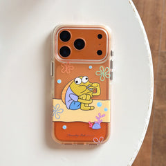 A top-down shot of a clear orange phone case with a funny yellow sitting fish illustration on a white tabletop.