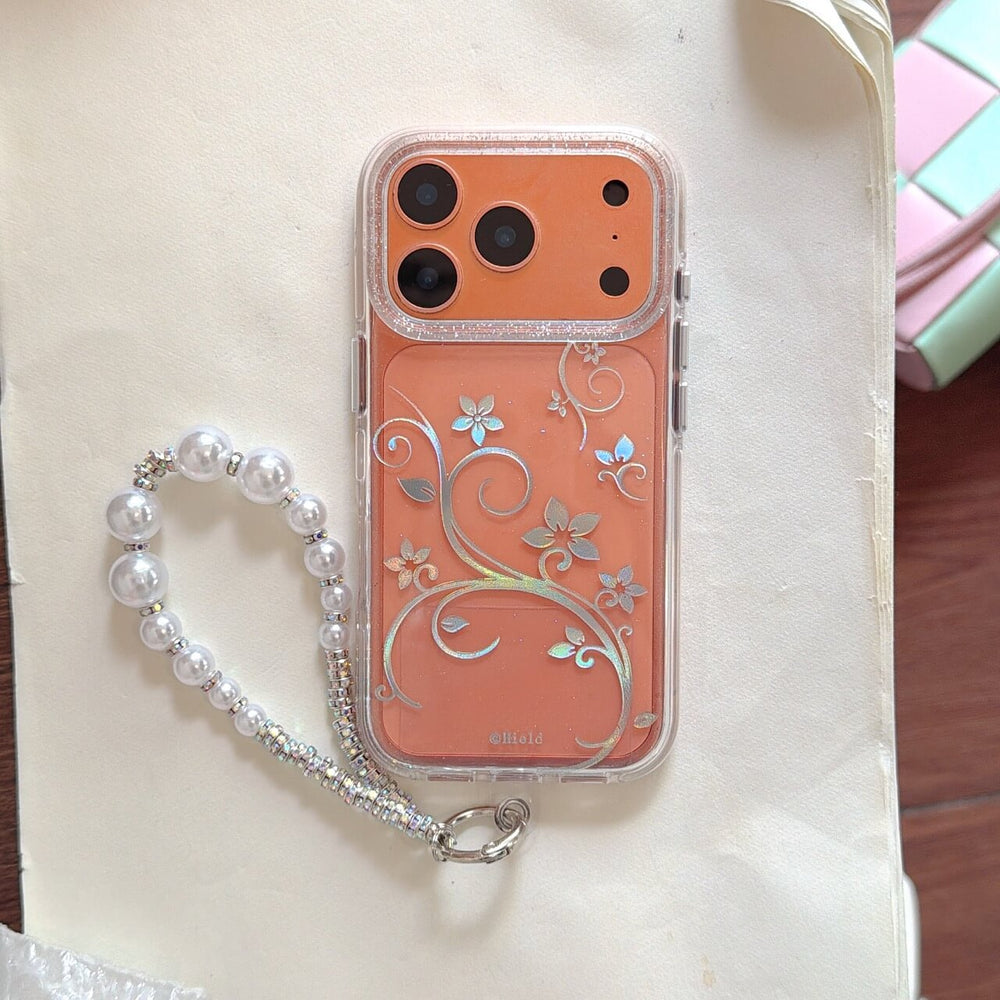 Orange iPhone in clear case with silver floral vine pattern and pearl strap
