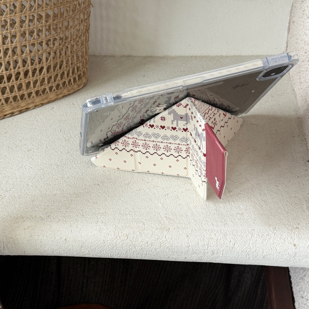 An iPad propped horizontally using an origami folding stand case on a white textured ledge with a woven rattan basket in the background.