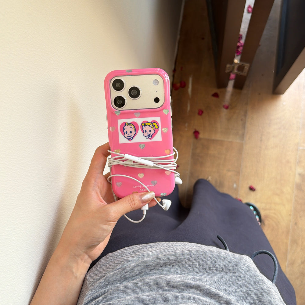Hand holding a pink holographic heart phone case with white earphones wrapped around the middle.