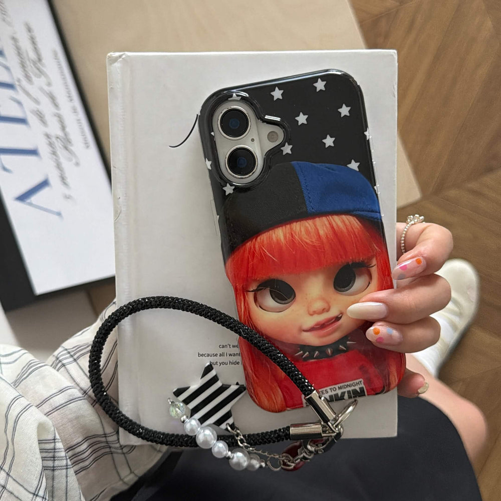 Hand holding a glossy red-haired Y2K doll iPhone case with star background.