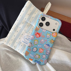 An angled view of a retro Japanese cartoon phone case resting on a striped fabric pillow.
