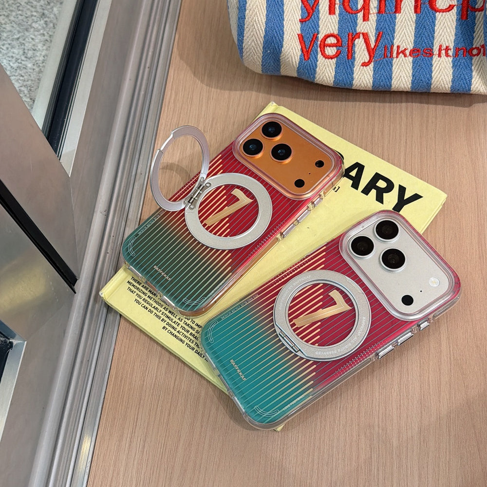 Top-down view of two iPhone covers featuring a colorful gradient scheme with a jersey number 7, resting on a yellow book with their metal ring holders extended.