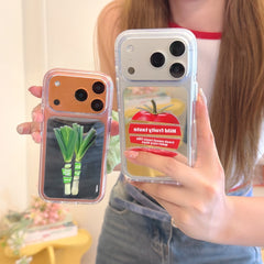 Close-up view of both tomato and green leek mirror iPhone cases held side-by-side to show different colors.