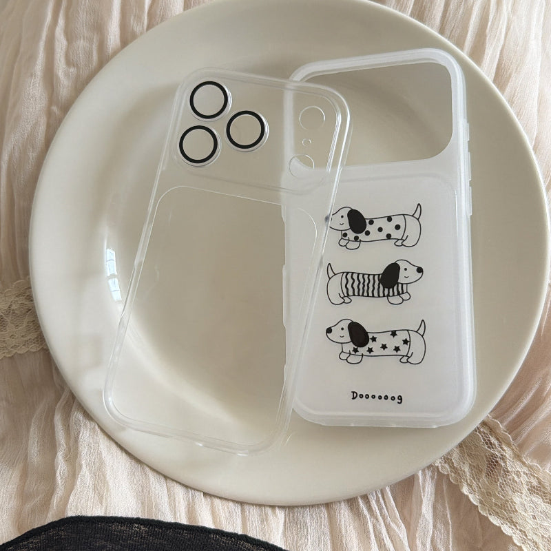 A transparent iPhone case with a cute dog insert resting on a white ceramic plate.
