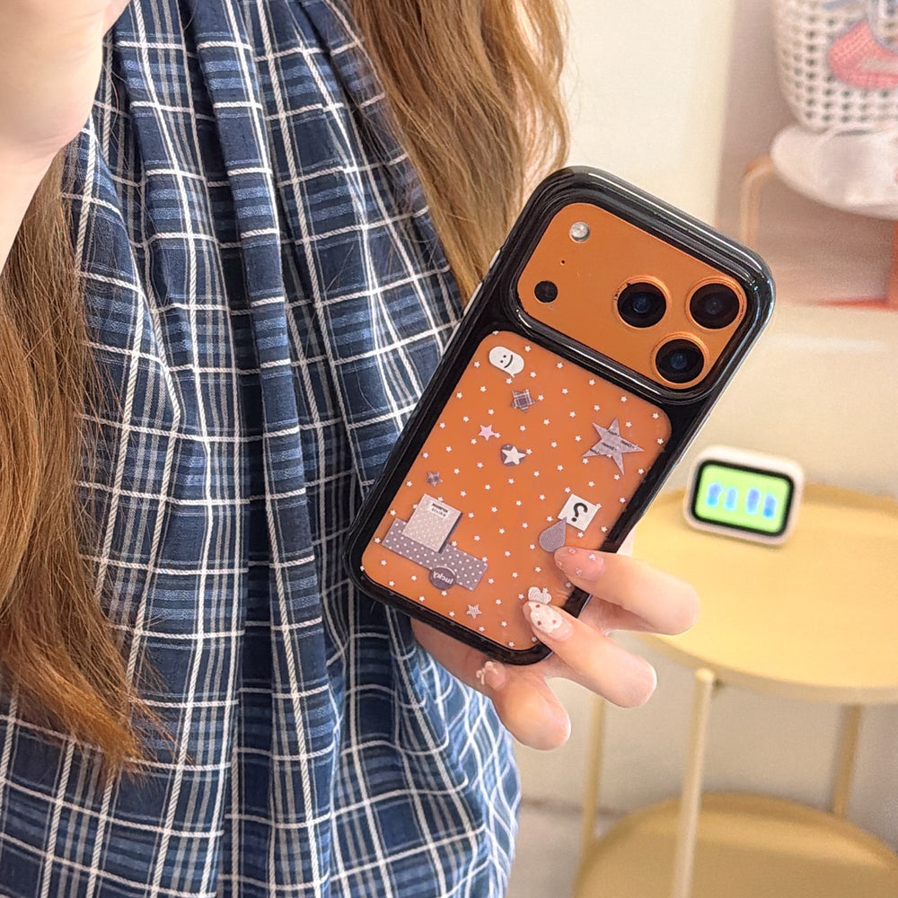 A close-up shot of a girl holding a vibrant orange Y2K doodle mirror phone case with a functional camera mirror.