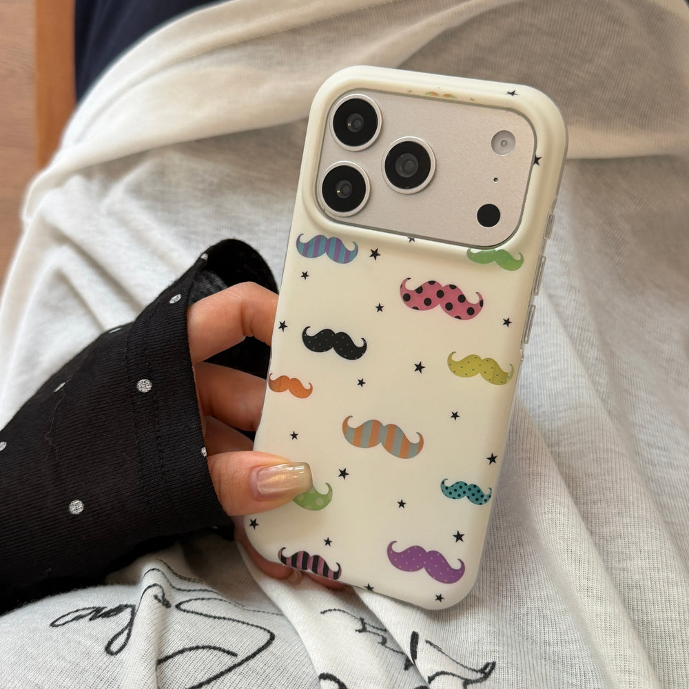 A close-up view of a hand holding the white mustache pattern phone case against a dotted top.