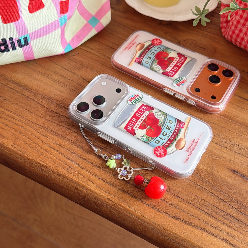 Two Y2K aesthetic tomato can phone cases with silver and orange metallic camera frames on a wooden table.