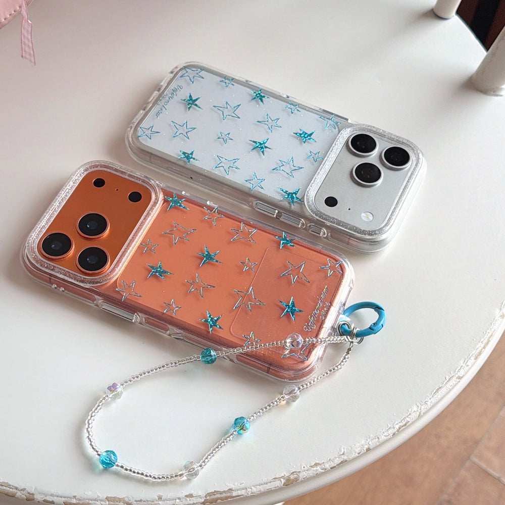 Silver and orange Y2K star phone cases with a beaded wristlet on a white table.