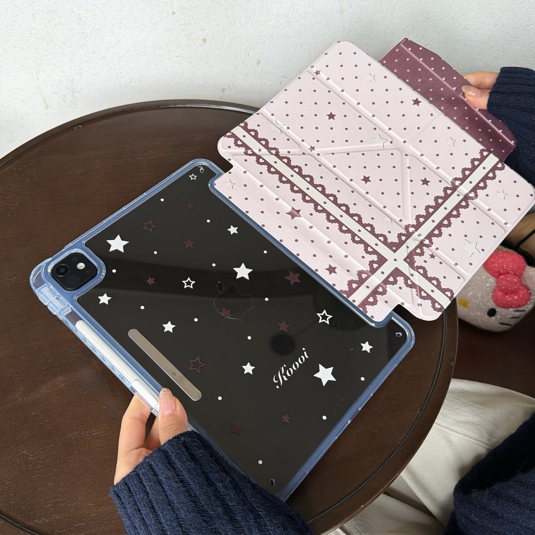 Hands separating the 2-in-1 magnetic split clear back shell from the pink polka dot lace folio flap of a kawaii iPad cover.