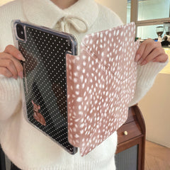 Hands separating the 2-in-1 magnetic split polka dot back panel with a small deer illustration from the pink deer-spot patterned cover.