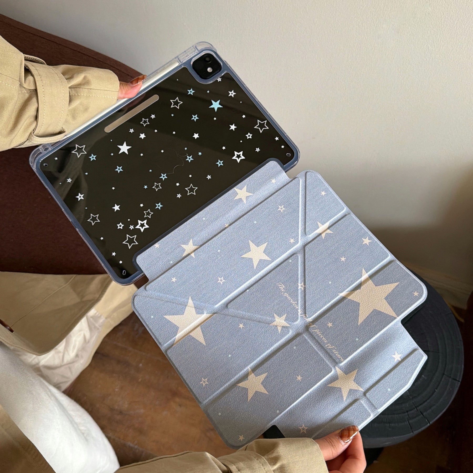 An open 2-in-1 magnetic split iPad case showing the blue starry inner folio flap connected to the clear back starry panel.