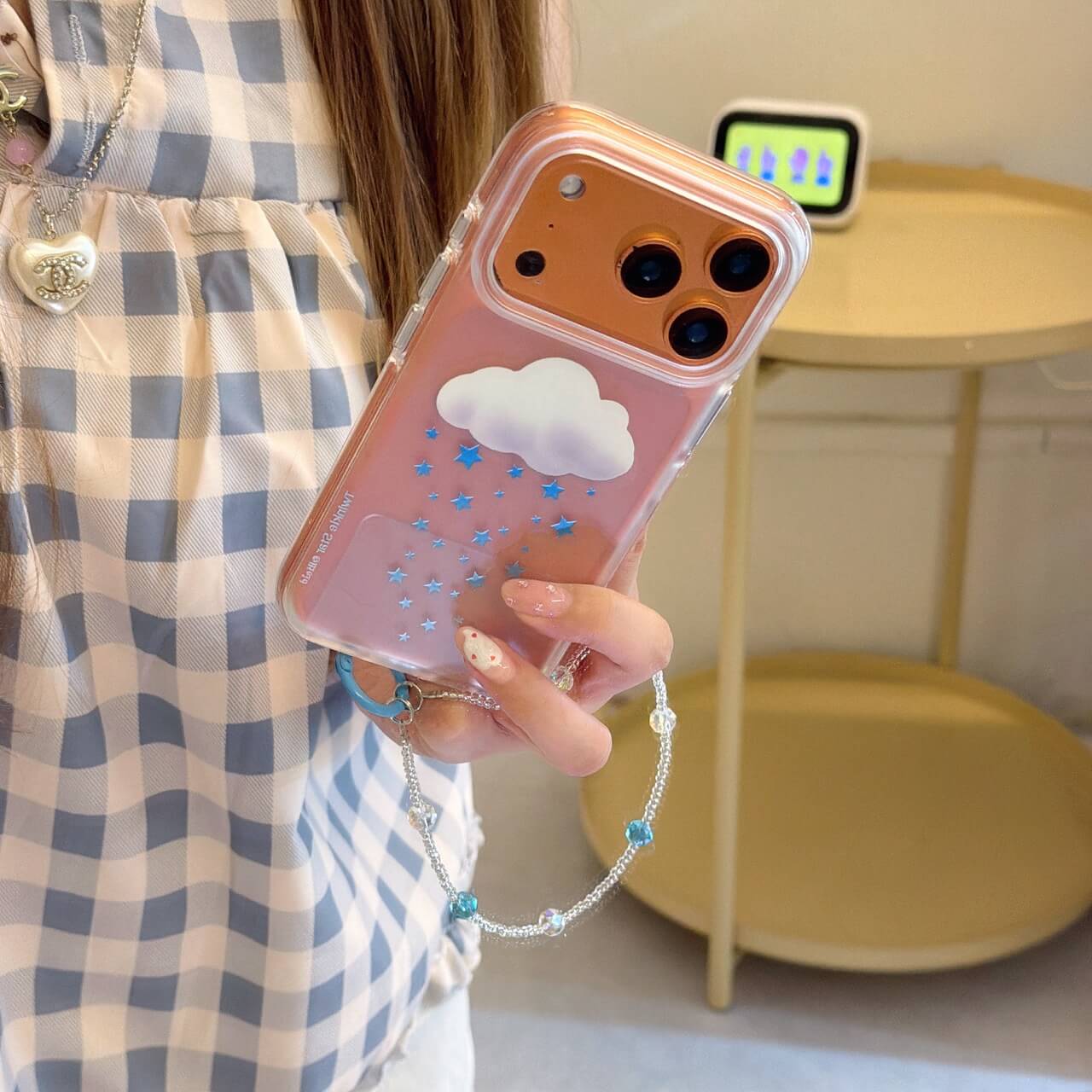 Flat lay of the 3D cloud and star rain phone case featuring a retro orange camera plate.