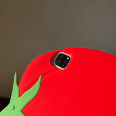 Detailed macro shot of the camera module cutout on a 3d silicone fruit tablet cover, showing the thick protective red borders and a corner of the green leaf stem.