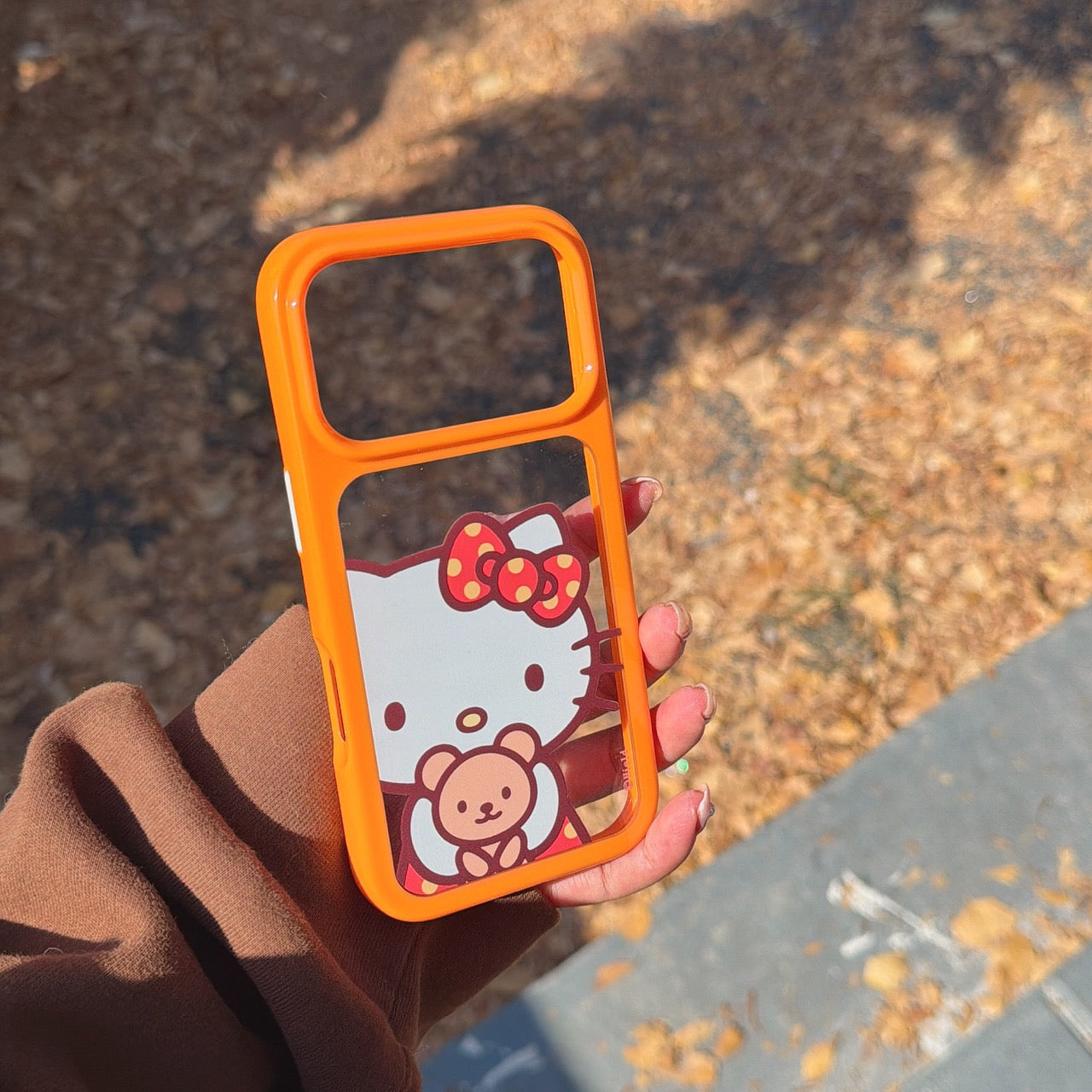 Orange-bordered Kitty hugging a bear rounded phone case