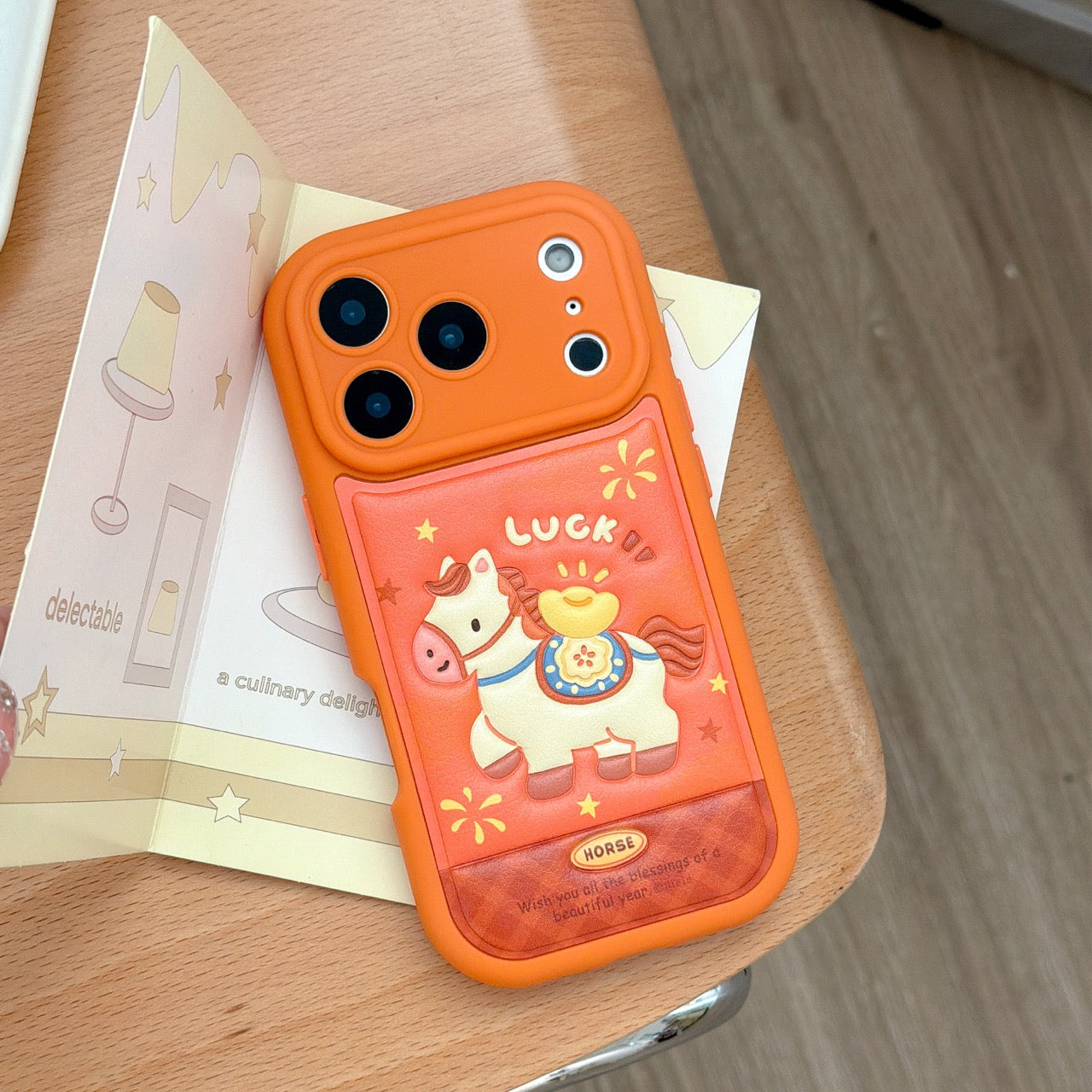 Orange-based 3D Apple phone case with gold ingot and pony design