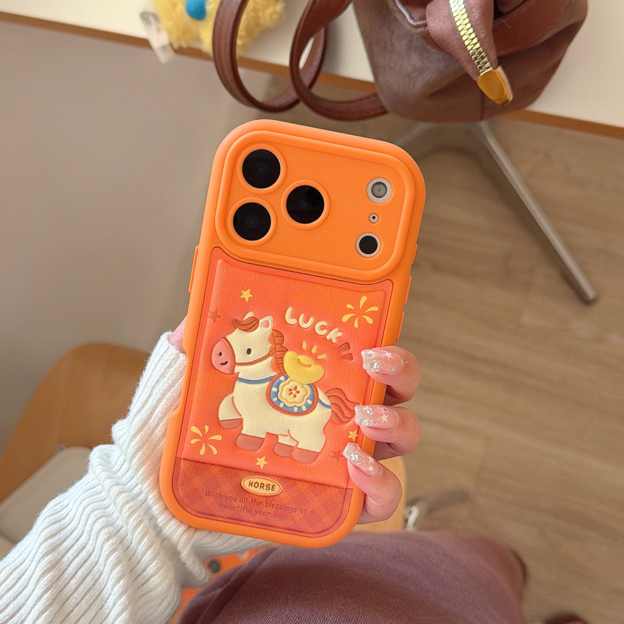 Orange-based 3D Apple phone case with gold ingot and pony design